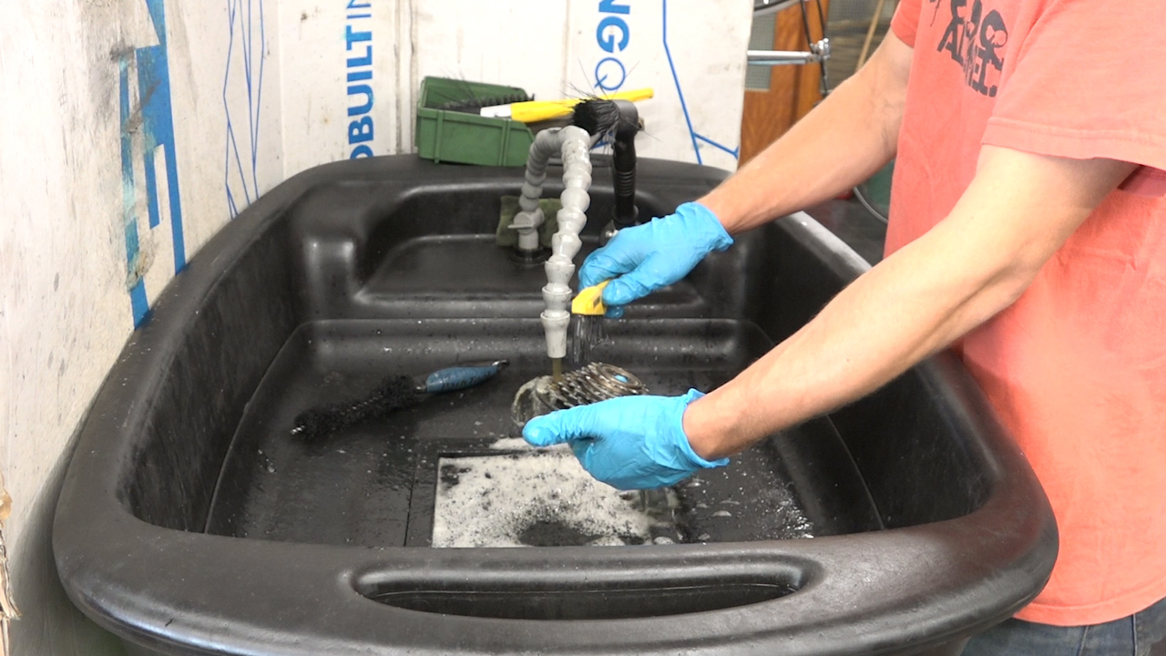 Bike parts are washed with a degreaser and brushed
