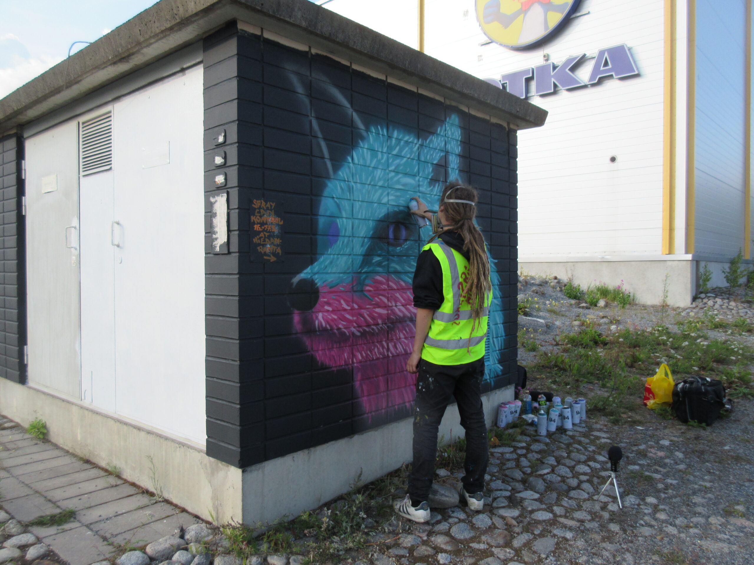 Graffiti artist painting a wall in a city