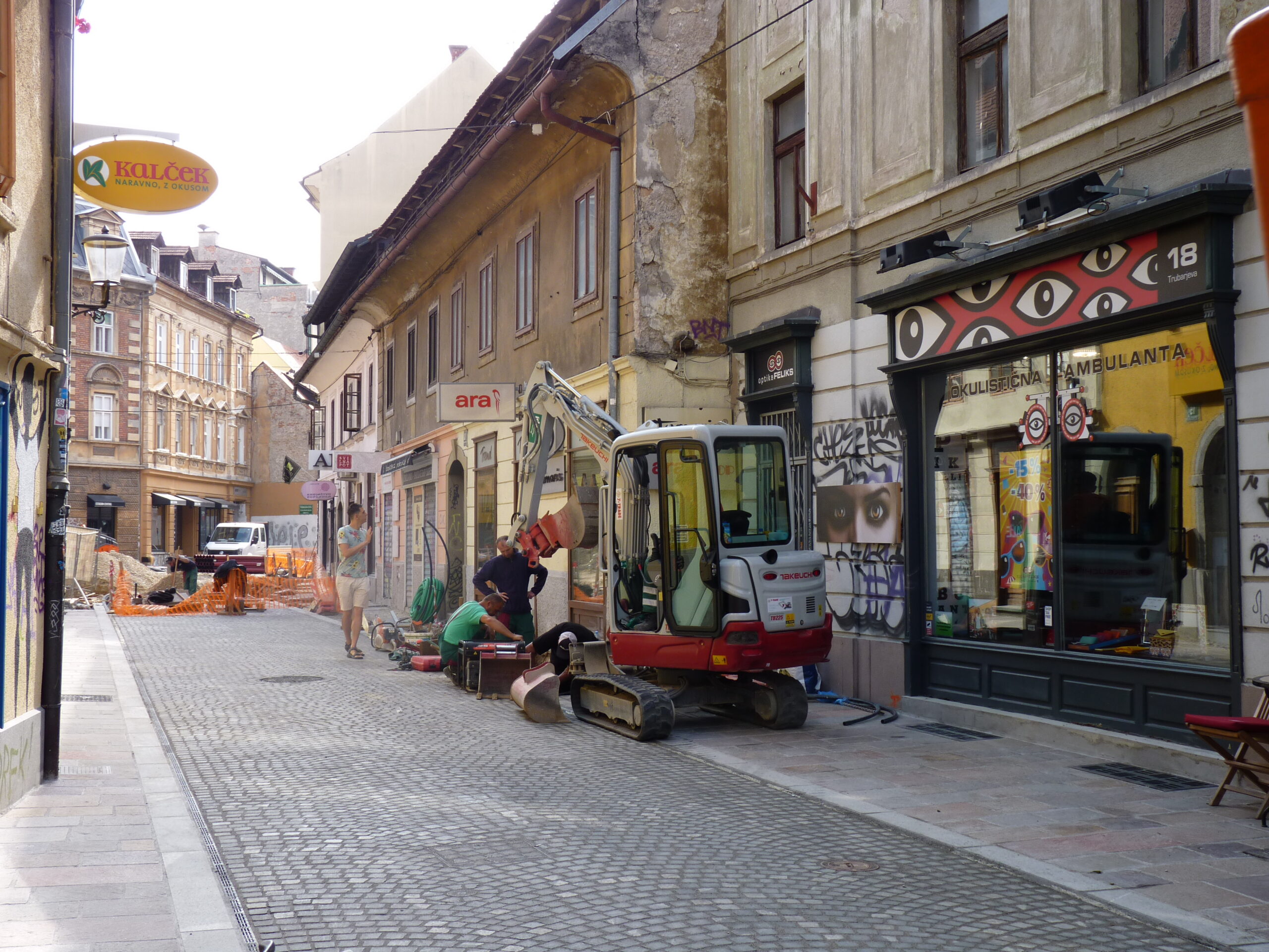 Walking down the street – building site, vans, lorries, people walking, talking, cycling; Ljubljana